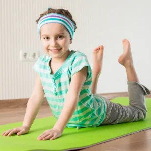 You can see a small child doing yoga in this image.